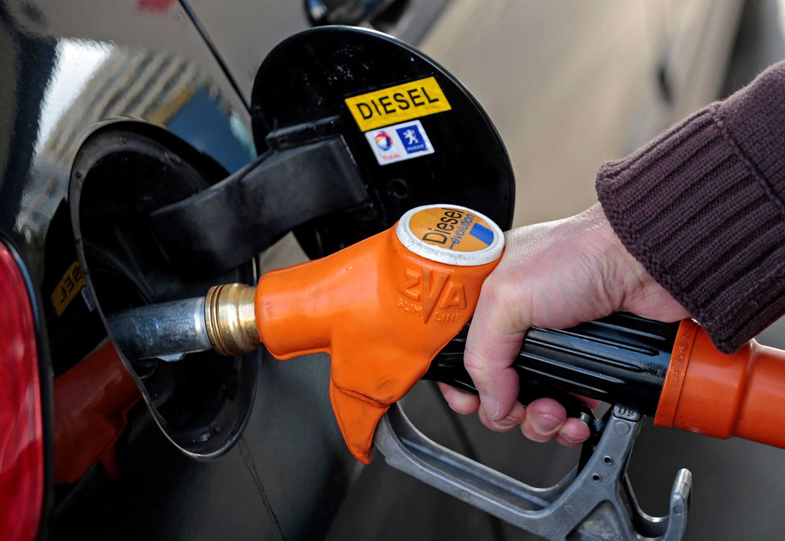 FILE PHOTO: A customer fills-up his car with diesel at a gas station in Nice